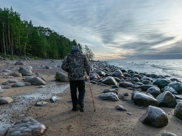 Foto achtergrondbeeld van een man die op een rots op het strand tegen de lucht staat