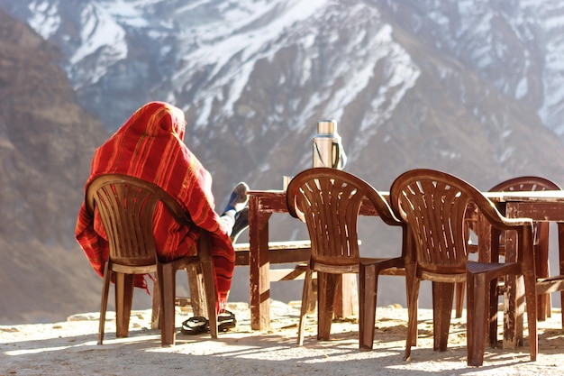 Foto achtergrondbeeld van een man die op een stoel zit tegen een met sneeuw bedekte berg