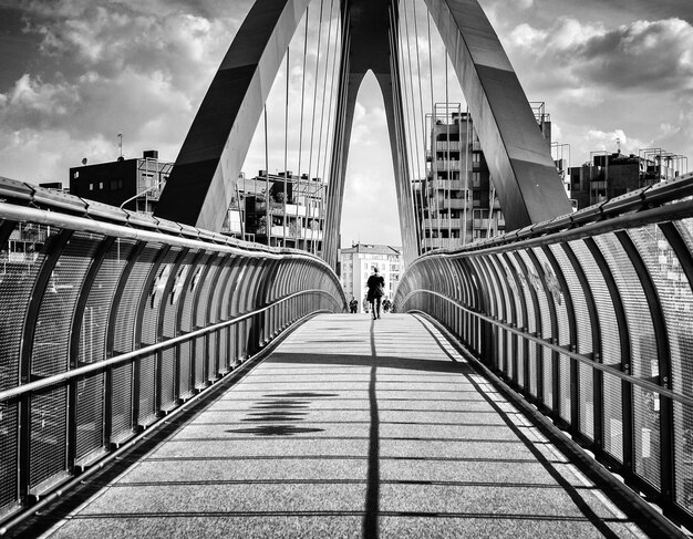 Achtergrondbeeld van een man die op een zonnige dag op een voetgangersbrug loopt
