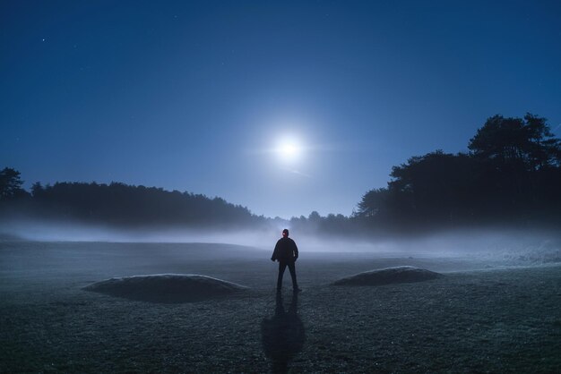 Foto achtergrondbeeld van een man die op het land tegen de lucht staat