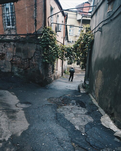 Foto achtergrondbeeld van een man die op straat loopt te midden van oude gebouwen
