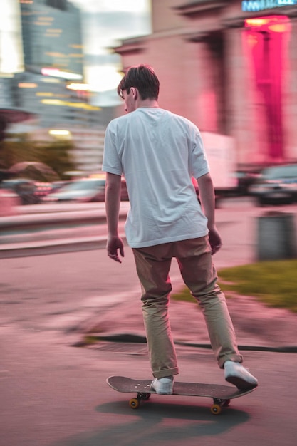 Achtergrondbeeld van een man die skateboard rijdt op de weg in de stad