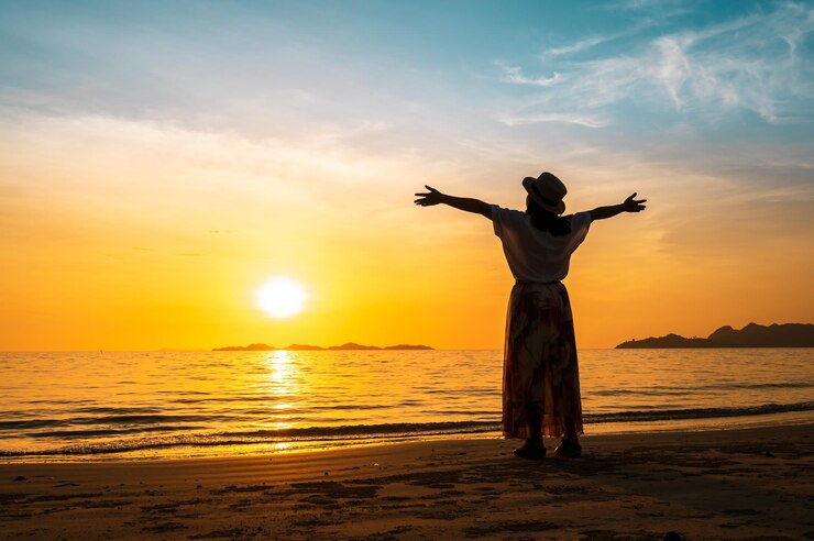 Foto achtergrondbeeld van een man die tijdens de zonsondergang op het strand staat