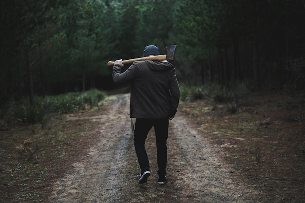 Achtergrondbeeld van een man met een bijl in het bos