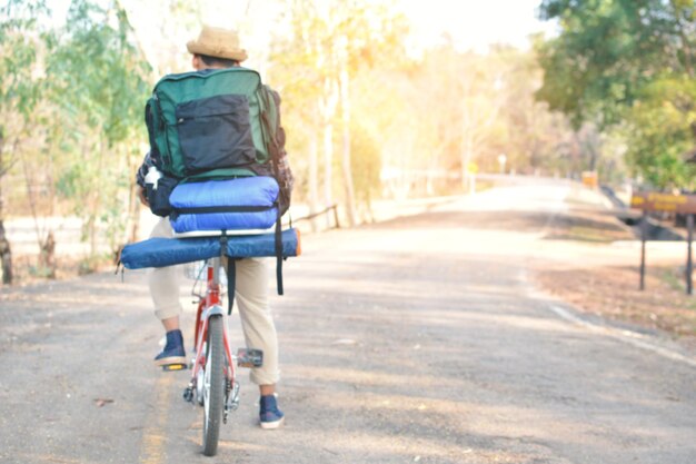 Foto achtergrondbeeld van een man met een rugzak die op een fiets op een voetpad rijdt