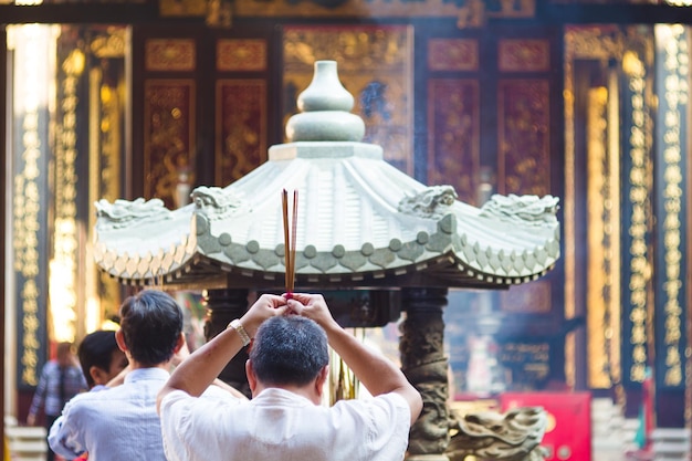 Achtergrondbeeld van een man met wierook in een Chinese tempel