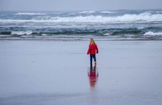 Achtergrondbeeld van een meisje dat op het strand staat