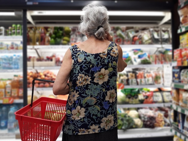 Achtergrondbeeld van een oudere vrouw die winkelt in een supermarkt