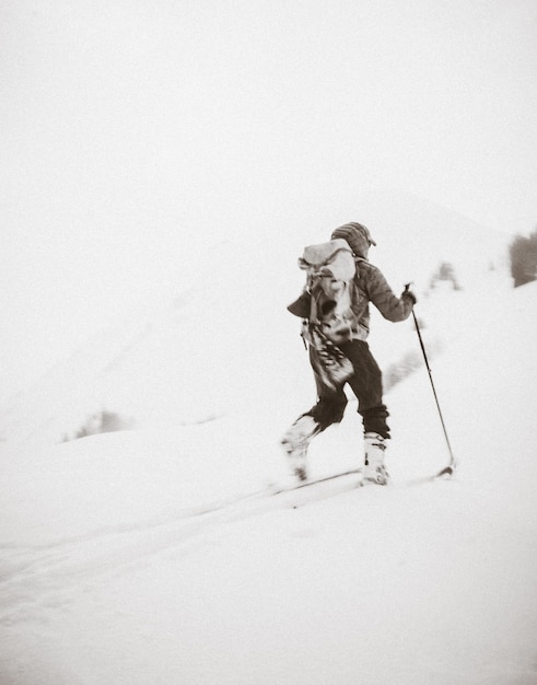 Achtergrondbeeld van een persoon die op een met sneeuw bedekte berg skiet