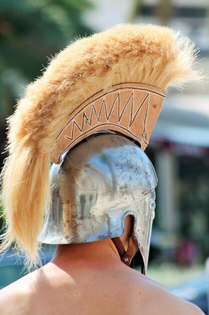 Foto achtergrondbeeld van een shirtloze man die een ridderhelm draagt tijdens het evenement