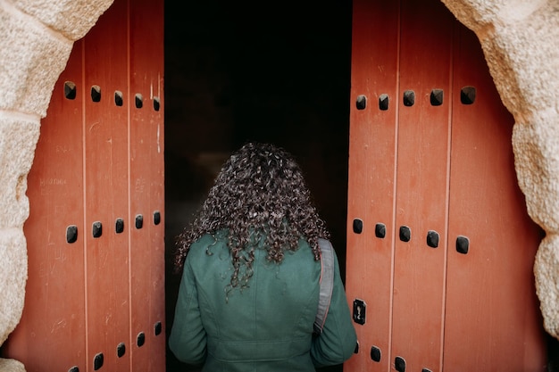 Achtergrondbeeld van een vrouw die door de deur van een historisch gebouw binnenkomt