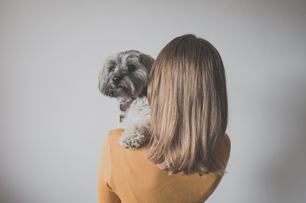 Achtergrondbeeld van een vrouw die een hond draagt op een witte achtergrond