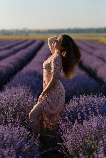 Foto achtergrondbeeld van een vrouw die langs de rijen van een lavendelveld loopt