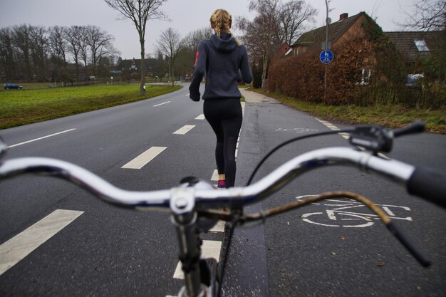 Foto achtergrondbeeld van een vrouw die op de weg jogt