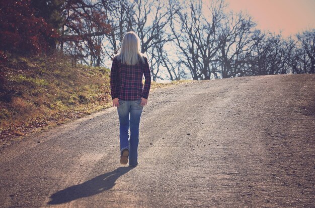 Foto achtergrondbeeld van een vrouw die op de weg loopt