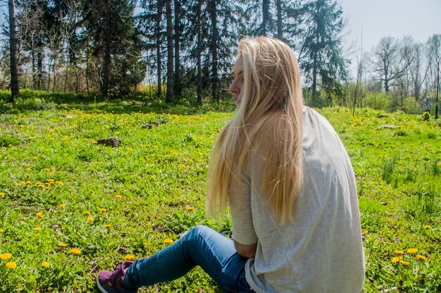 Achtergrondbeeld van een vrouw die op een grasveld zit