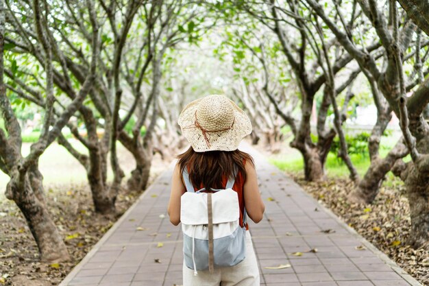 Foto achtergrondbeeld van een vrouw die op een voetpad tussen bomen staat