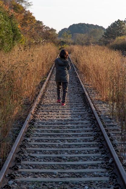 Foto achtergrondbeeld van een vrouw die op het spoor loopt