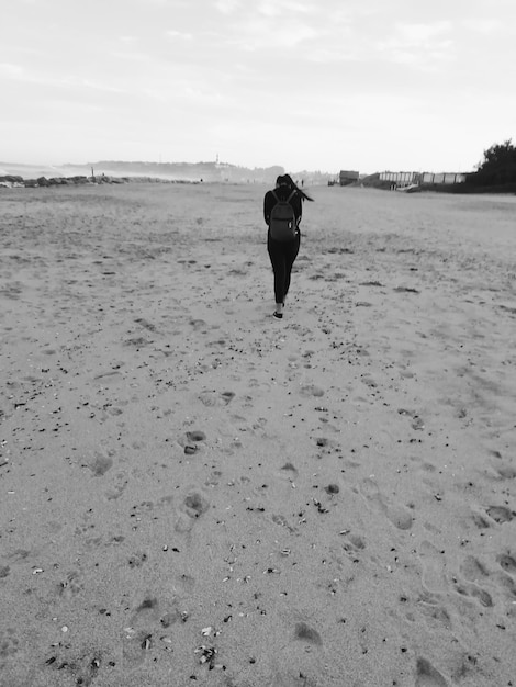 Foto achtergrondbeeld van een vrouw die op het strand loopt