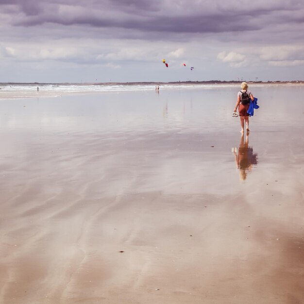 Foto achtergrondbeeld van een vrouw die op het strand loopt