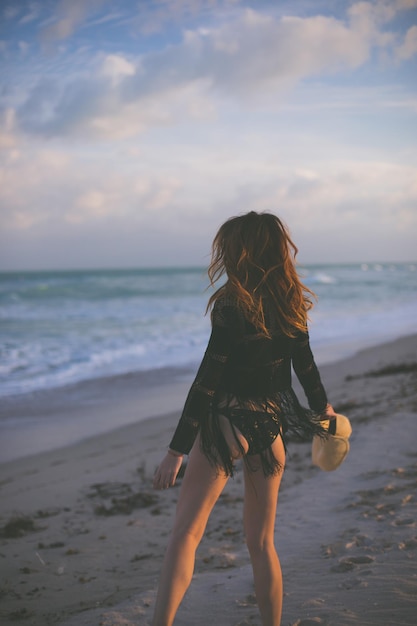 Achtergrondbeeld van een vrouw die op het strand staat