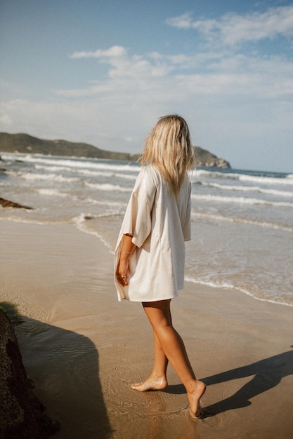 Achtergrondbeeld van een vrouw die op het strand tegen de lucht staat