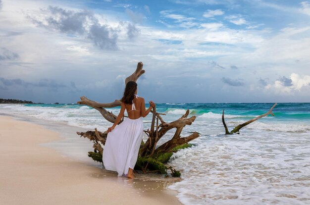 Foto achtergrondbeeld van een vrouw die op het strand tegen de lucht staat