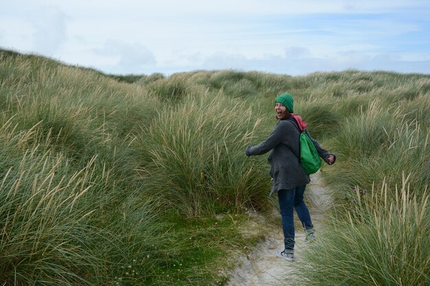 Foto achtergrondbeeld van een vrouw die op het veld loopt tegen de lucht