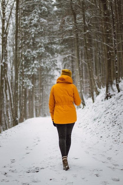 Foto achtergrondbeeld van een vrouw die op sneeuw bedekt land loopt