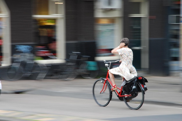 Achtergrondbeeld van een vrouw die op straat fietst