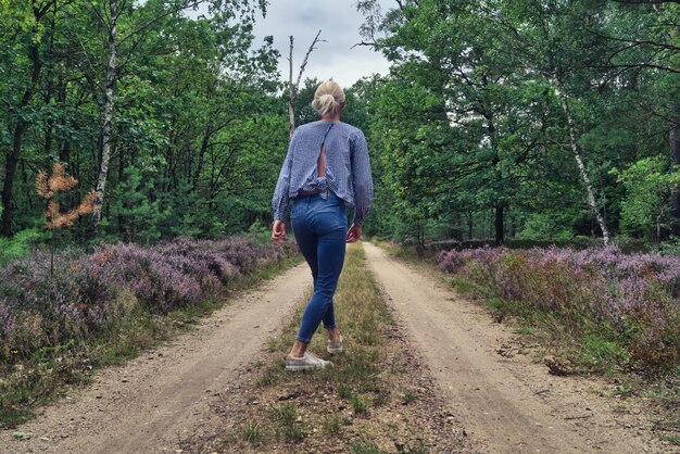 Foto achtergrondbeeld van een vrouw die op straat loopt te midden van bomen