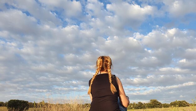 Foto achtergrondbeeld van een vrouw die tegen de lucht staat