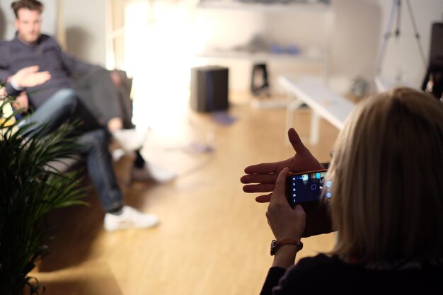 Foto achtergrondbeeld van een vrouw die thuis een telefoon gebruikt