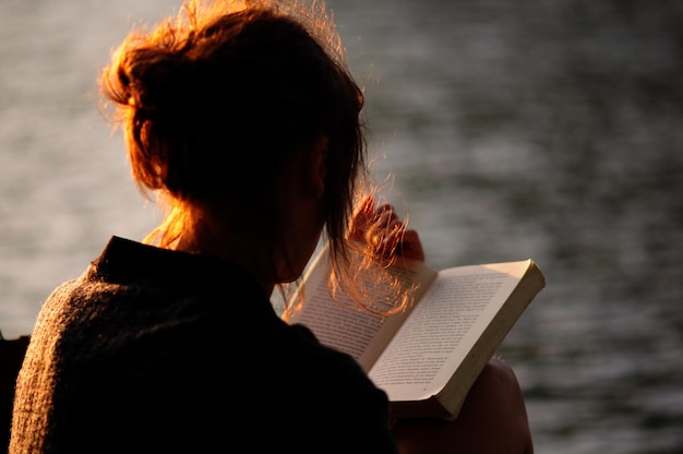 Achtergrondbeeld van een vrouw met een boek tegen het meer