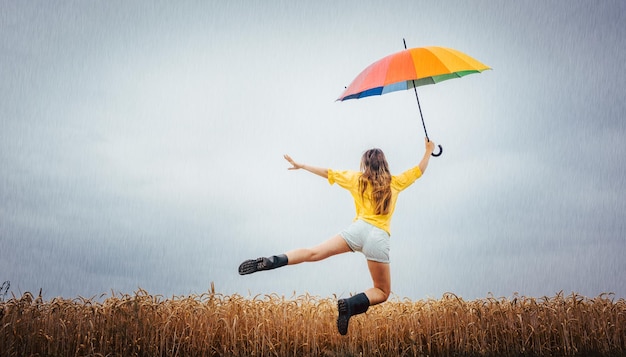Achtergrondbeeld van een vrouw met een paraplu terwijl ze tegen een bewolkte lucht zweeft