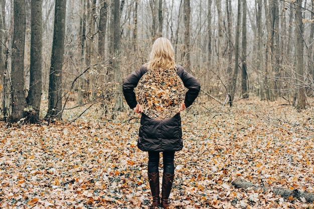 Achtergrondbeeld van een vrouw met een spiegel terwijl ze in het bos staat