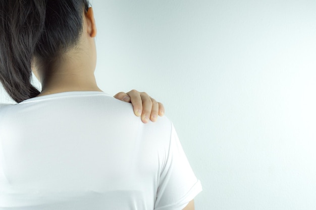 Achtergrondbeeld van een vrouw met rugpijn die tegen een witte achtergrond staat