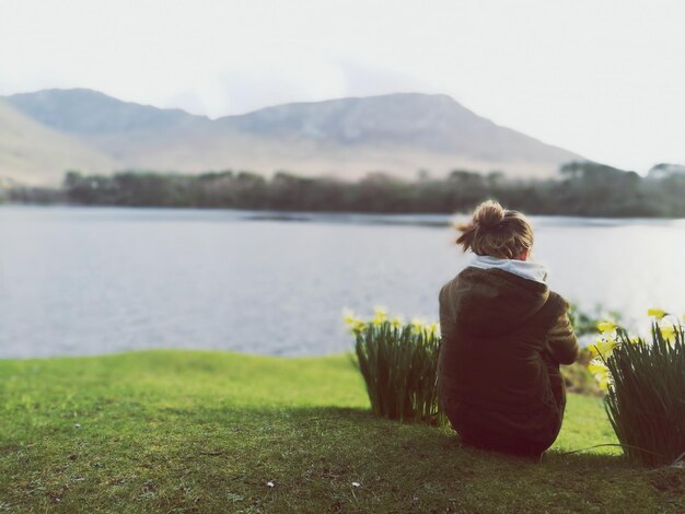 Foto achtergrondbeeld van een vrouw met uitzicht op een rustig meer