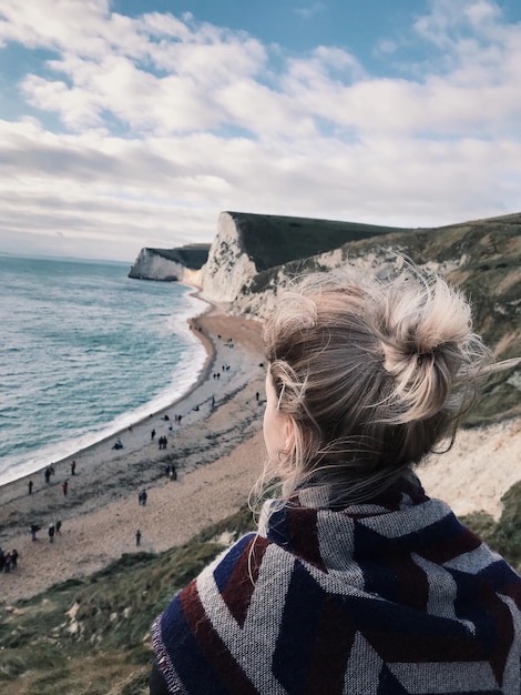 Achtergrondbeeld van een vrouw op de berg bij het strand tegen de lucht