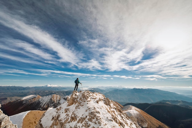 Foto achtergrondbeeld van een vrouw op een besneeuwde berg tegen een bewolkte lucht