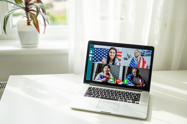 Achtergrondbeeld van een zakenvrouw die met haar collega's in het videoconferentieteam praat met behulp van een laptop voor een online vergadering in een videogesprek vanuit huis in Amerika.