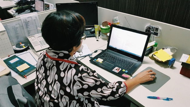 Achtergrondbeeld van een zakenvrouw die op kantoor met een laptop werkt