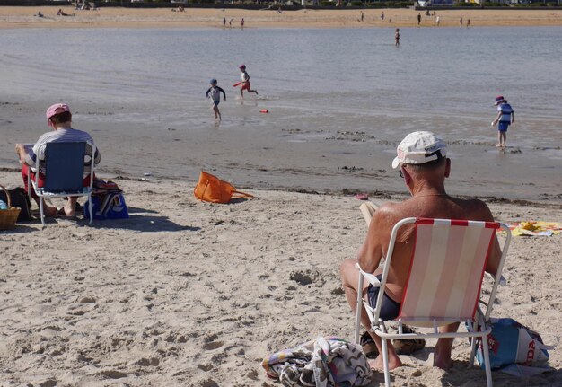 Foto achtergrondbeeld van mannen die op een leunstoel op het strand zitten