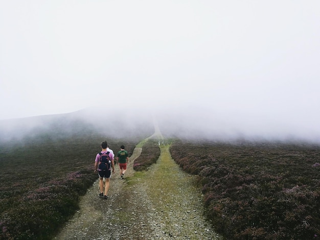 Foto achtergrondbeeld van mannen die op een onverharde weg midden in het veld lopen