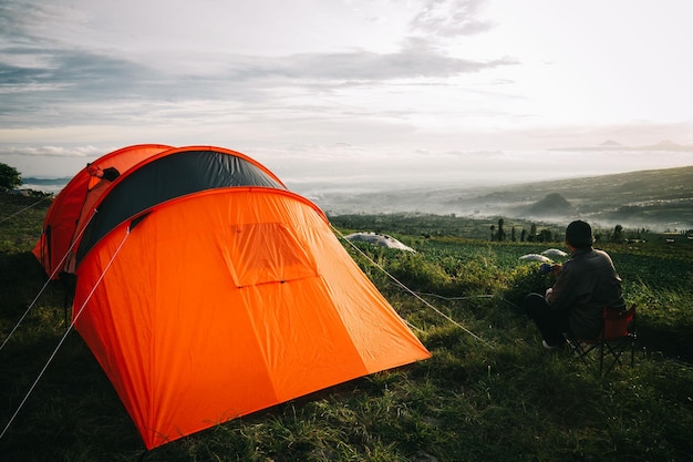 Achtergrondbeeld van mannen die op een tent tegen de lucht zitten
