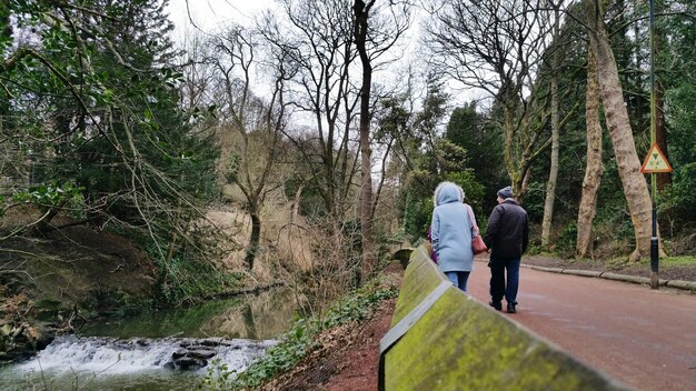 Foto achtergrondbeeld van mensen die langs de rivier lopen