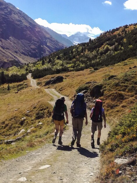 Foto achtergrondbeeld van mensen die op een bergweg tegen de lucht lopen