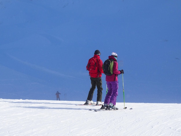 Achtergrondbeeld van mensen die op een met sneeuw bedekte berg skiën