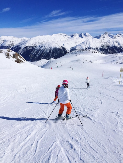 Achtergrondbeeld van mensen die skiën op een met sneeuw bedekte berg tegen de lucht