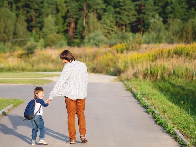 Achtergrondbeeld van moeder en zoon die op de weg lopen